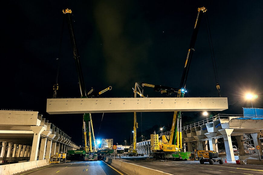 Mobile cranes execute complex nighttime infrastructure overpass installation